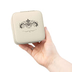 Compact pink jewelry travel organizer held in a hand, showcasing elegant floral design for jewelry storage.