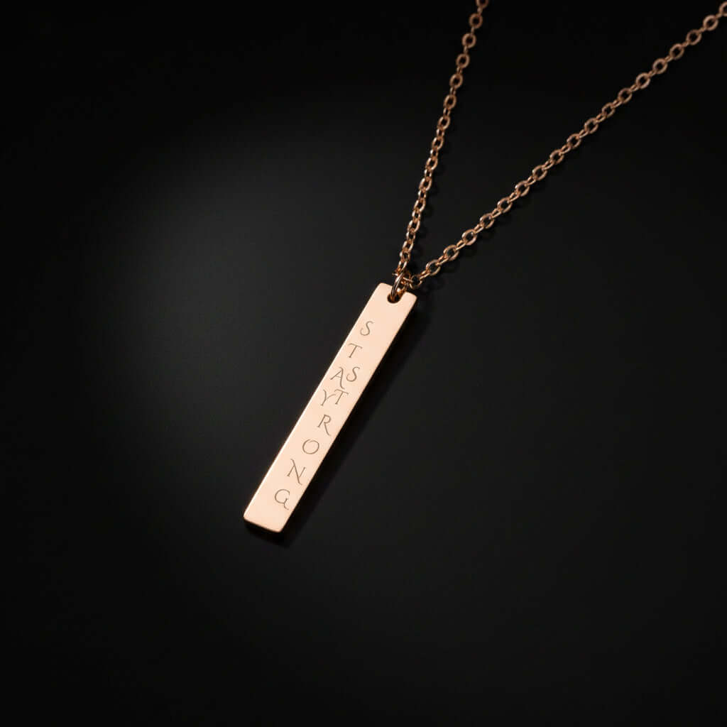 Rose gold necklace with a bar pendant engraved with 'Stay Strong' on a white background Hadi Craft USA
