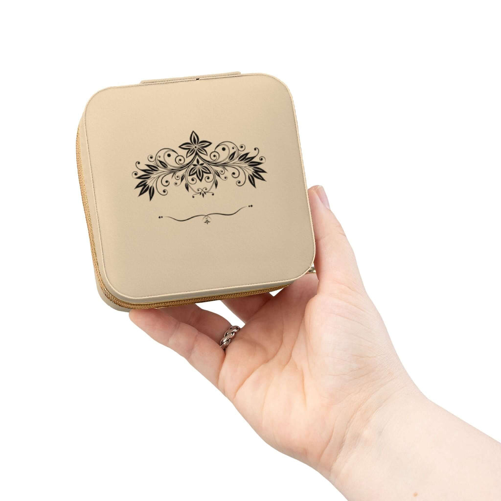 Compact pink jewelry travel organizer held in a hand, showcasing elegant floral design for storing rings and earrings.